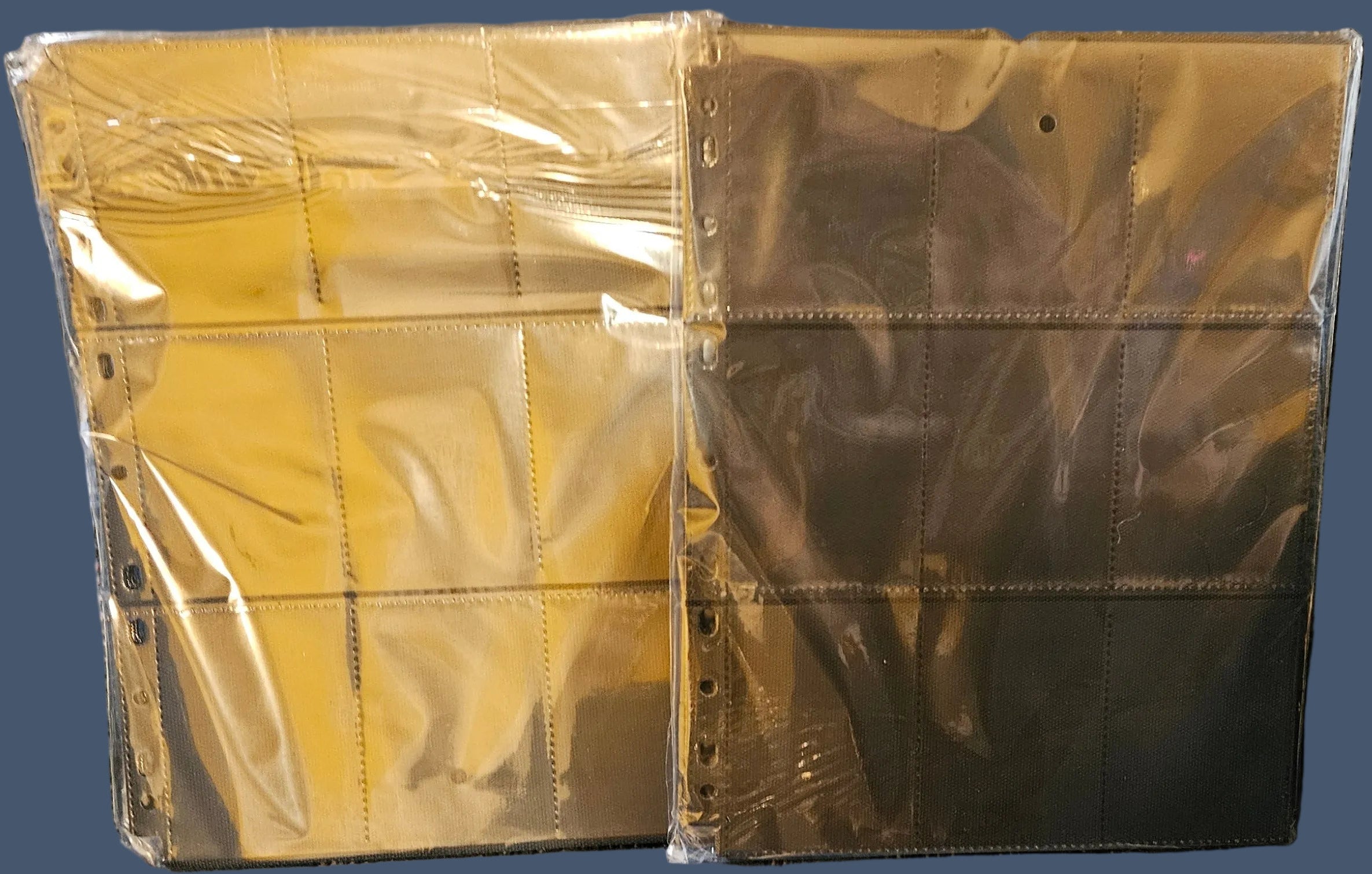 Gold-colored metal panels in clear plastic packaging on a textured gray surface